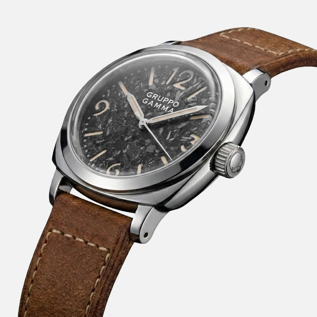 A Gruppo Gamma wristwatch featuring a dark textured dial, a silver-tone stainless steel case, and a brown leather strap with white contrast stitching, shown on a clean white background.