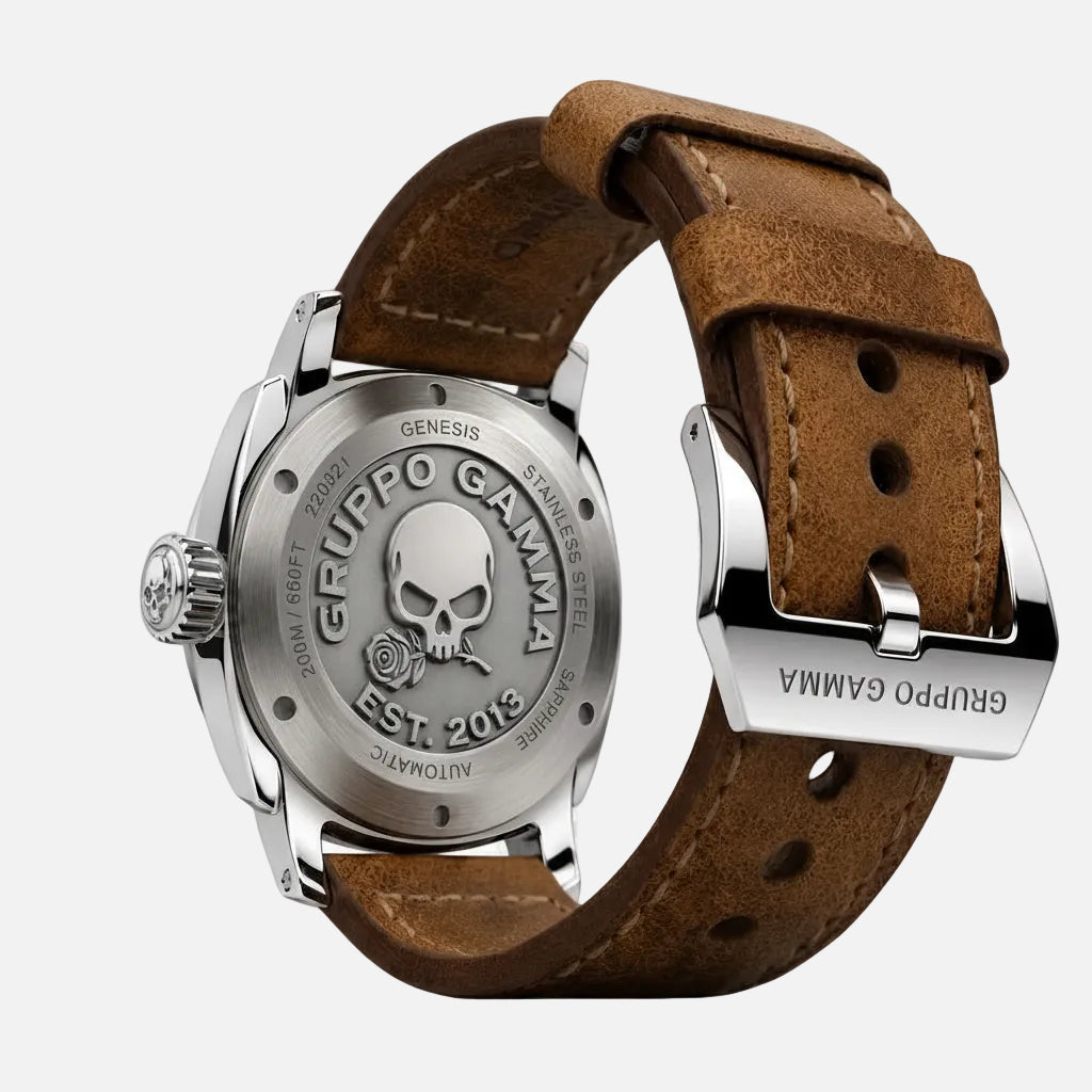 A close-up studio shot of the back of a wristwatch with a brown leather strap and a silver stainless steel case. The case is engraved with a skull and rose logo and the brand name 'GRUPPO GAMMA'.
